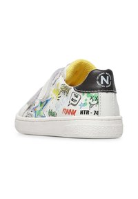 Sneaker bianchi con un design colorato di graffiti, motivo a stelle, cinturini in Velcro, suola in gomma testurizzata e una fodera interna gialla.