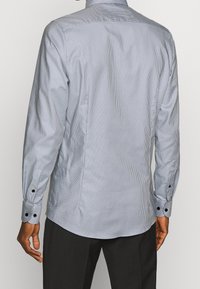 Lange mouwen knoopshirt in lichtblauw met een fijn gestreept patroon, contrasterende zwarte knopen op de manchetten en een gladde katoenmix stof.