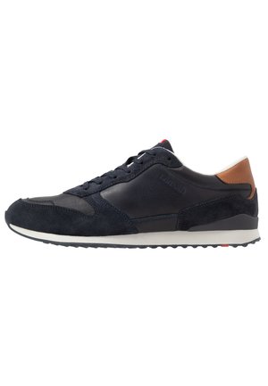 Men's navy sneakers made from leather and suede, featuring a rubber sole, tonal laces, and a brown leather heel accent.