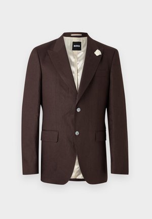 Blazer da uomo marrone scuro con due bottoni, rever a incastro, tasche con patta, fodera crema e una piccola spilla a forma di fiore bianco sul rever sinistro.