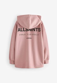 Ružičasta dukserica izrađena od mekanog materijala, sa kapuljačom, dugim rukavima i velikim crnim tekstom na leđima koji glasi "ALLSAINTS LONDON" uz japanske znakove.