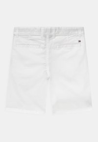 Hvide herreshorts med bæltesløjfer, to baglommer med paspolering og et lille rektangulært logo på højre lomme.