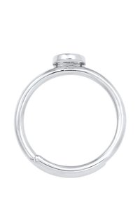 Anillo plateado elegante con una banda circular suave y una pequeña parte superior plana. Presenta un acabado pulido y una marca estampada en el interior.