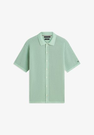 Jasnozielona, krótka koszulka polo z dzianiny z przodem na guziki i teksturowanym wzorem siateczki, z klasycznym kołnierzykiem.