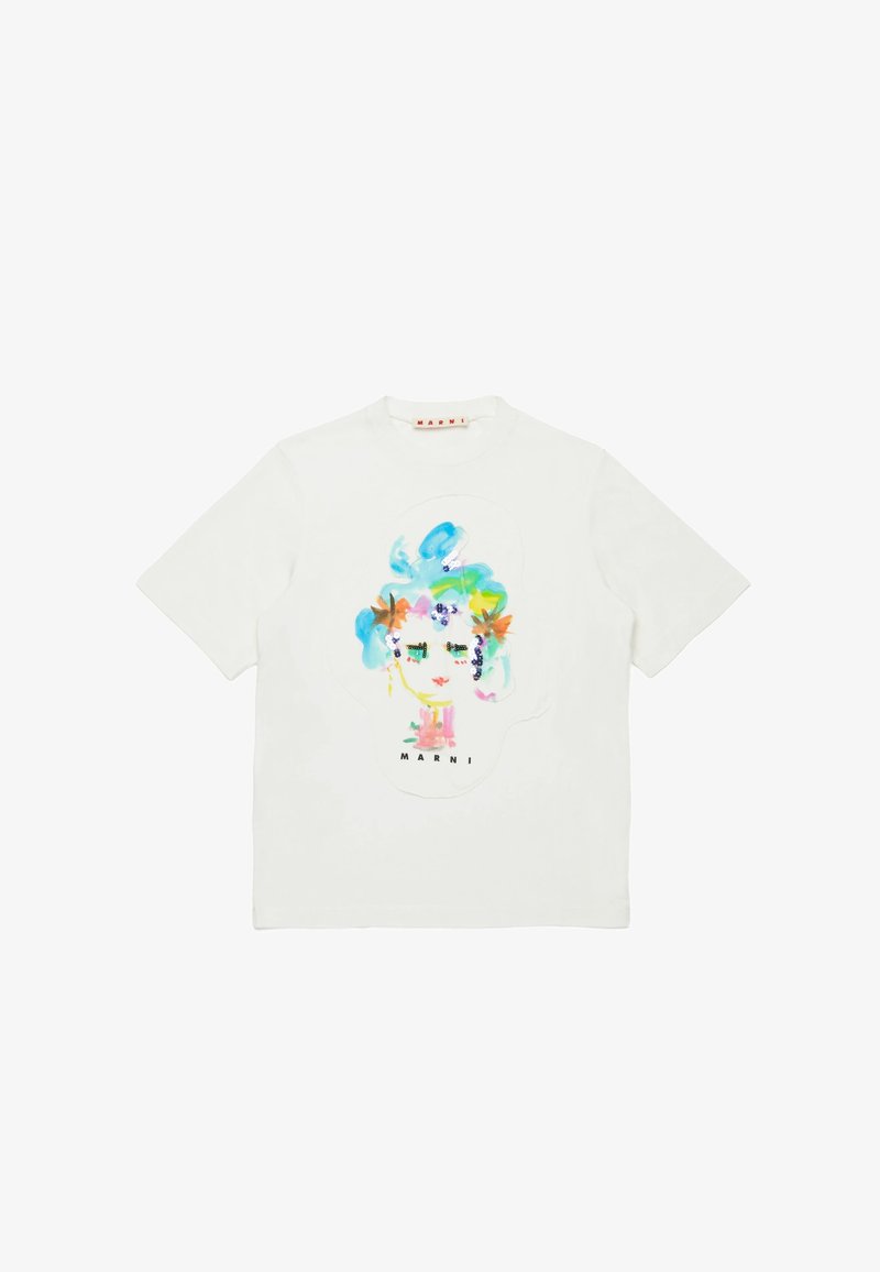 T-shirt en coton blanc présentant un graphique de visage abstrait coloré avec des accents floraux et des sequins. Col rond et manches courtes.