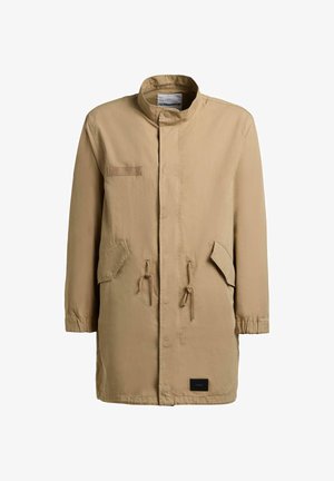 Cappotto lungo beige con collo alto, due tasche anteriori con pattina e dettagli con coulisse, polsini elastici e chiusura con bottoni nascosta.