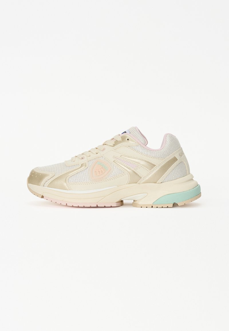 Beige sportieve schoen met een bovenkant van mesh, roze accenten op de kraag en een mintgroene buitenzool. Kenmerken zijn een ronde neus en veters.