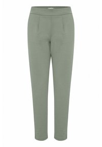 Zielone, elastyczne spodnie z dopasowanym krojem, z dwoma fałdami z przodu i prostymi nogawkami, sięgającymi tuż ponad kostkę.