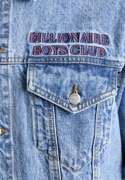 Denimjack met blauwe stof, borstzak met zilverkleurige hardware en rode geborduurde tekst "BILLIONAIRE BOYS CLUB".