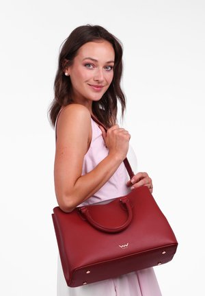Rote Lederhandtasche mit doppelten Griffen, rechteckiger Form, strukturiertem Finish und goldenen Hardwareakzenten. Die Tasche hat ein Logo an der Vorderseite.
