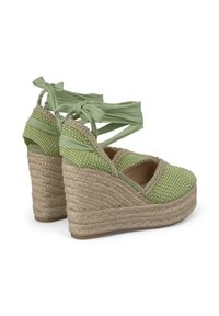 Zeppe espadrillas verdi con tomaia intrecciata e piattaforma in juta. Presentano morbide fasce in raso e un accento dorato lungo il bordo.