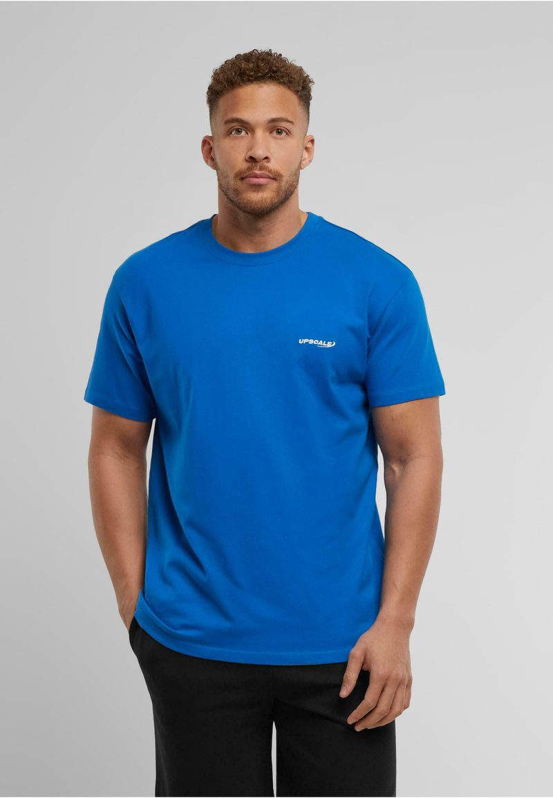Blå bomulds-t-shirt med rund halsudskæring, korte ærmer og et lille hvidt logo på venstre bryst. Glat tekstur, afslappet pasform.
