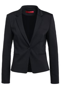 Blazer noir cintré avec revers crantés, fermeture à un bouton, deux poches avant et étiquette intérieure rouge. Tissu lisse, coupe ajustée.