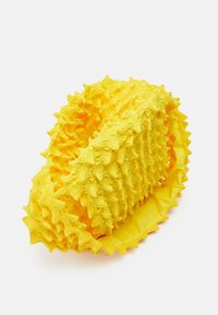 Yellow textured product shaped like a fruit, with spiky star-like details and a smooth interior, crafted from flexible material.