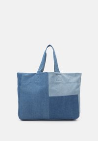 Denim tote bag med et patchworkdesign i forskellige nuancer af blå, med to håndtag og firkantede syninger. Stor og rummelig.