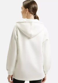 Biała hoodie z kapturem o oversize'owym kroju, długimi rękawami, ściągaczem przy mankietach i detalem szwu na plecach. Miękka tkanina o gładkiej fakturze.