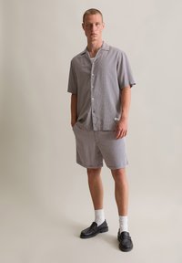 Korte mouwen overhemden met knopen en bijpassende korte broek in een geruit patroon, met een ontspannen pasvorm, lichte stof en een klassieke kraag.