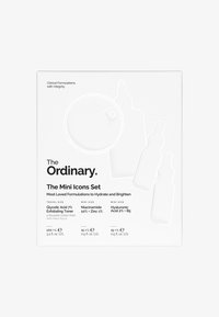 L'emballage du set d'icônes mini de The Ordinary, en blanc avec des formes de produits en relief, comprend des flacons compte-gouttes et un compartiment rond pour des coussinets en coton.