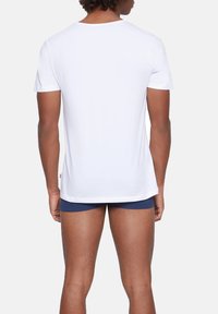 White short-sleeve t-shirt made of soft cotton. Features a crew neckline and a straight cut, with a smooth, unadorned texture.