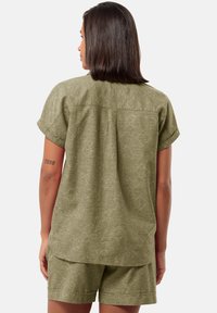 Maglia verde oliva a maniche corte con vestibilità ampia e leggero motivo testurizzato, abbinata a pantaloni corti coordinati, entrambi con orli casual.