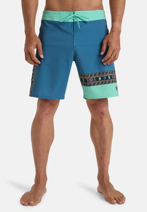 Herrarnas badshorts i blått och mintgrönt, med en mönstrad accentband och dragsko i midjan. Tillverkade av ett lätt och stretchigt material.