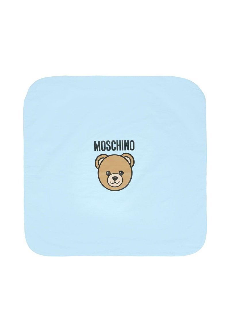 Jasnoniebieski koc z grafiką twarzy niedźwiedzia w kolorze brązowym oraz wyraźnym czarnym napisem "MOSCHINO" u góry. Miękka tkanina z zaokrąglonymi brzegami.