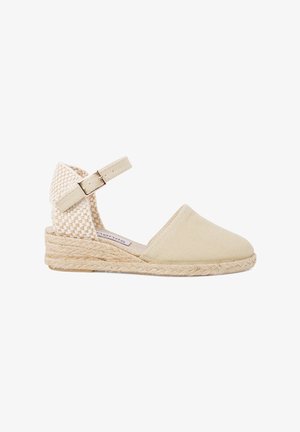 Espadrille en toile beige avec un dos tissé, une bride à la cheville et une semelle en jute. Texture lisse et bout arrondi.
