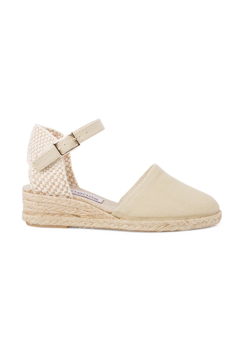 Beige kangastest espadrillid, millel on kootud selg, pahkluu rihm ja jute tõstehari. Sile tekstuur ja ümar varvas.