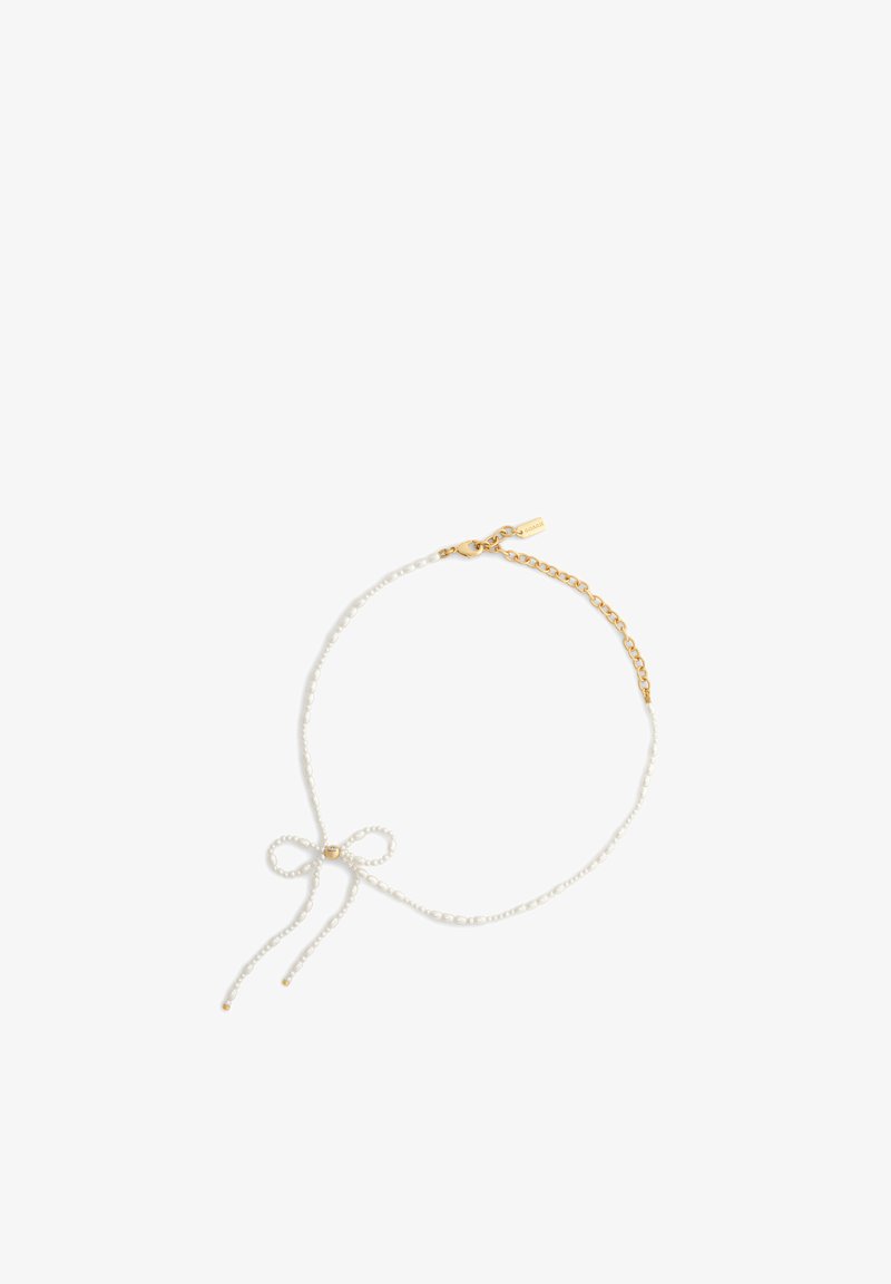 Collier délicat avec de petites perles blanches formant un nœud, extension de chaîne en or et fermeture à mousqueton sur fond blanc.