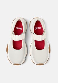 Scarpe in tessuto bianco con punta rotonda, dotate di una fascia elastica sopra il collo del piede e un interno rosso. Suola in gomma color sabbia.