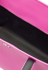 Sac à main en cuir texturé rose avec un intérieur noir, doté d'une fermeture éclair et de poignées doubles. Aucun compartiment supplémentaire visible.