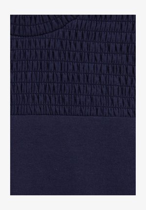 Navy blue textile with two sections: top features gathered texture and ribbed neckline, bottom has a smooth, flat finish.