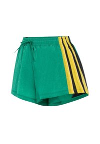 Gröna shorts med elastisk midjeband, med gula och svarta vertikala ränder på ena sidan och ett lätt, strukturerat tyg.