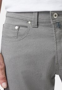 Grijze denim jeans met een gestructureerde stof, standaard vijf-pocket ontwerp, metalen hardware en een kleine merklabel op de tailleband.