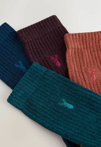 Ribbed knit socks in dark blue, deep burgundy, teal, and copper, featuring contrasting embroidered lobster motifs in matching colors.