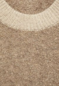 Pull en laine beige avec un col rond côtelé blanc et un motif tricoté texturé et duveteux.