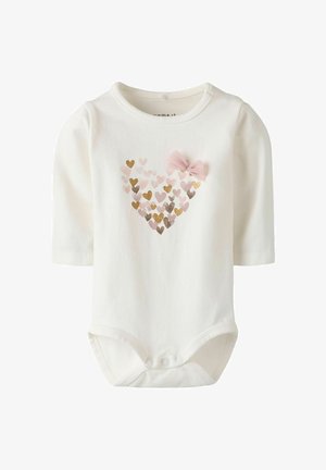 White long-sleeve onesie features a heart made of multicolored hearts in pink, gold, and brown, adorned with a pink bow on the left side.