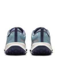Chaussures de sport en GORE-TEX bleu clair avec des accents en tissu texturé, des finitions bleu marine et une semelle intermédiaire blanche. La semelle extérieure présente un motif de traction adhérent.