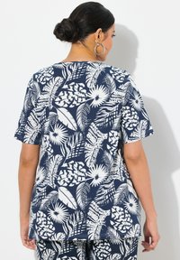 Tmavě modré tričko s bílým tropickým listovým a květinovým potiskem. Krátké rukávy, volný střih, hladká textura a kulatý výstřih.