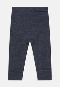 Mørkeblå leggings laget av teksturert, elastisk stoff. Har en elastisk midjebånd og ribbede mansjetter ved anklene.