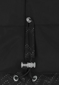 Schwarzer Stoff mit matter Textur und einem Zugkordelsystem. Ein dekoratives Element beinhaltet einen dunkelgrauen, gemusterten Akzent mit subtilen Punkten.