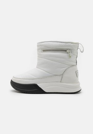 Bottines blanches isolées avec une surface texturée, une fermeture éclair sur le côté et une semelle en caoutchouc noire contrastante. Dispose d'une languette pour un enfilage facile.