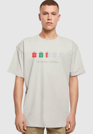 Bomuld T-shirt i lysegrå med korte ærmer. Har fire farverige gaveæske-designs og teksten "Julegave undervejs..." i midten.