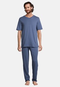 Ensemble de pyjama pour homme en tissu doux de couleur bleu clair. Manches courtes et pantalons longs avec une coupe décontractée. Texture lisse, détails minimalistes.