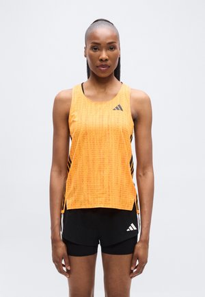 Oransje atletisk tanktopp med et teksturert mønster, sideslisser og svarte aksenter. Kombinert med svarte shorts med en logo.