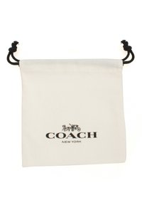 Witte katoenen trekkkoordtas met een zwart "COACH NEW YORK" logo en een decoratief ontwerp van een paard en wagen. Zachte textuur, eenvoudige vorm.