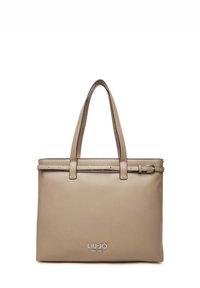Borsa tote in pelle beige con due manici superiori, una tracolla decorativa con borchie e un logo impresso sulla parte anteriore. Finitura liscia.