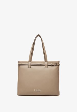 Bolso tote de cuero beige con dos asas superiores, una correa decorativa con tachuelas y un logo grabado en la parte frontal. Acabado liso.