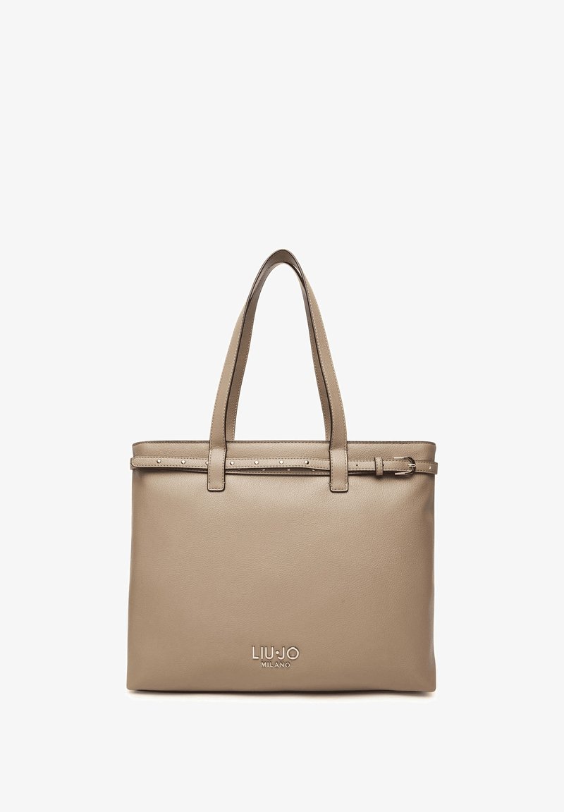 Borsa tote in pelle beige con due manici superiori, una tracolla decorativa con borchie e un logo impresso sulla parte anteriore. Finitura liscia.