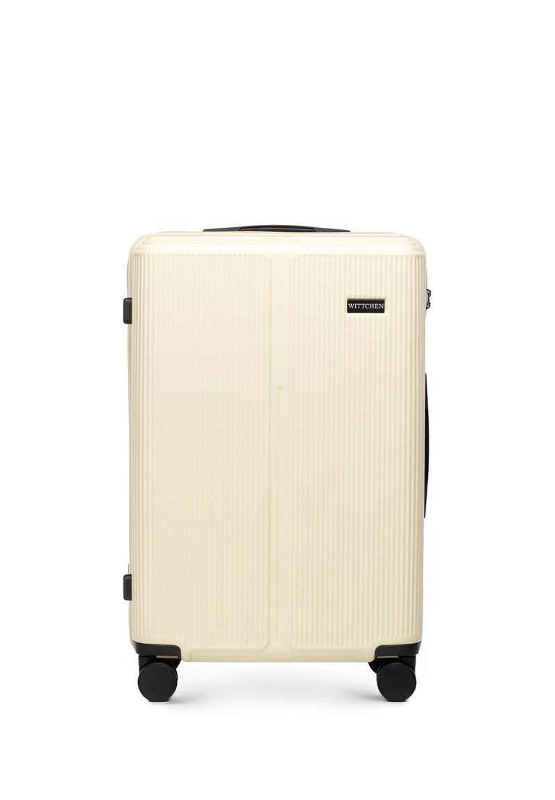 Hard-shell koffer in crème met verticale ribbels, zwarte accenten en vier zwarte wielen voor gemakkelijke mobiliteit. Voorzien van een handvat bovenop.